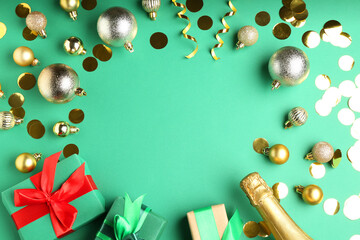 Flat lay composition with confetti and bottle of sparkling wine on green background, space for text. Christmas decor
