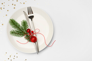 Christmas table setting with plate, cutlery and festive decor on white background, flat lay. Space...