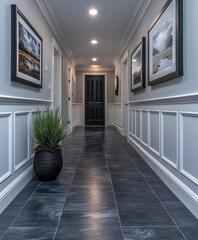 A hallway with clean white walls, dark grey flooring, and black accents on photo frames and pendant lights, creating a modern and elegant look