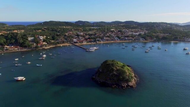 Wide aerial shot of Orla Bardot bay with boats and scenic coastline in B&uacute;zios, Rio de Janeiro.