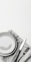 Classic white ceramic plate with a fork and knife on a linen tablecloth, viewed from above. Perfect for cafe menus, kitchen decor, or elegant dining presentations.
