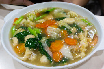 Capcay, stir fried vegetables with shrimp, meatballs and chicken. Served in white plate