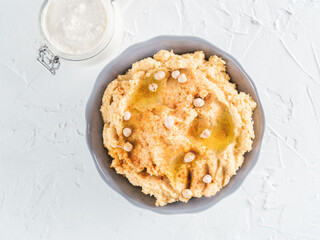 Homemade hummus in gray bowl and tahini. Traditional middle eastern homemade appetizer hummus - healthy vegan paste snack. Vegetarian diet,nutrition protein food concept and idea.Top view or flat-lay.