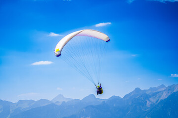 Paragliding in the sky. Paraglider flying over Landscape sun set Concept of extreme sport, taking adventure challenge.