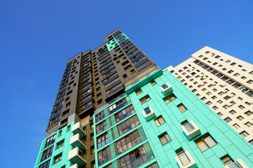 Modern colourful building on blue sky. Skyscraper facade. Modern High rise residential facade. Windows of Skyscraper. Architecture building exterior, window house block. High Rise house background.