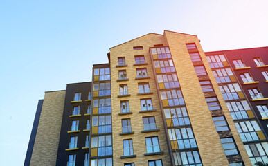 Fototapeta premium Modern facade building on blue sky. Skyscraper facade. Modern High rise residential facade. Windows of Skyscraper. Architecture building exterior, window house block. High Rise house background.