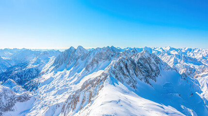 Snow-covered mountain range under a clear blue sky with peaks and ridges visible in bright sunlight