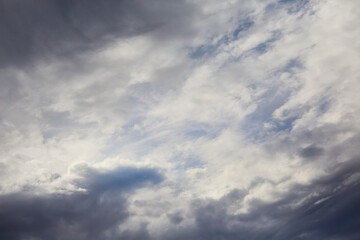 Fototapeta premium White clouds torn by the wind, storm formation, wind swirling clouds in the sky, celestial landscape with storm clouds.