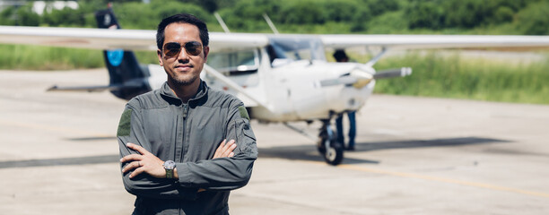 Pilot in uniform at airport. Asian Confident male pilot in uniform  and checking flight plan