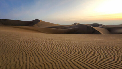 SUNSET. THE SUN FALLS ON THE DUNES. HUACACHINA DESERT. ICA, PERU. BEAUTIFUL SUNSET.