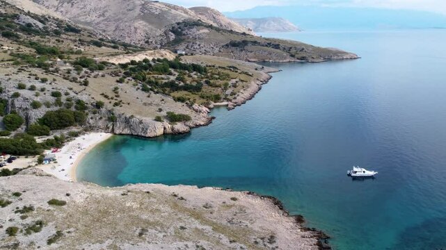 Drone Moving Right to Left over Turquoise Cove and Motor Yacht in Stara Ba&scaron;ka, Krk Island, Croatia