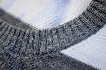 Close-up of a gray striped sweater showing intricate knit texture and detail. Perfect for fashion, textile, and fabric themed projects.