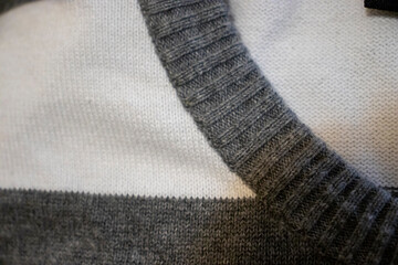 Close-up of a cozy gray and white striped sweater showcasing its texture and detailing. Perfect for fashion and textile enthusiasts. Ideal for clothing retail or design inspirations.