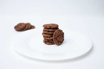 A stack of chocolate chip cookies sitting on a white plate