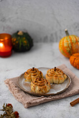 Pumpkin cinnamon rolls. Fresh homemade Cinnamon Rolls in the form of pumpkins. Bakery for Halloween or Thanksgiving party. Cozy autumn, winter still life with pumpkins.