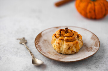 Pumpkin cinnamon rolls. Fresh homemade Cinnamon Rolls in the form of pumpkins. Bakery for Halloween or Thanksgiving party. Cozy autumn, winter still life with pumpkins.