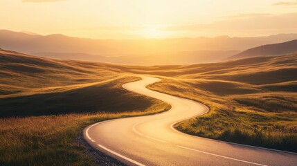 Fototapeta premium A scenic winding road curves through rolling hills bathed in golden sunset light, with distant mountains on the horizon creating a peaceful landscape.
