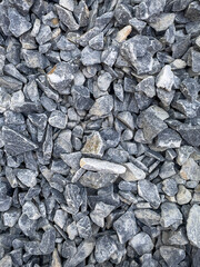 Grey natural smooth pebbles as texture or background, pebbles in a garden bed