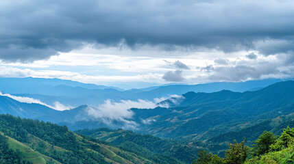Obraz premium Amazing wild nature view of layer of mountain forest landscape with cloudy sky. Natural green scenery of cloud and mountain slopes background 