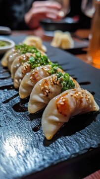 Gyoza dumplings with Shrimp on black stone plate with soy sauce