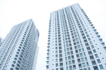 Low angle photo of an apartment building or high-rise residential building in the Pluit area, North Jakarta, Indonesia with bright sky background. Empty blank copy text space