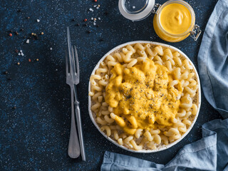 Pasta with vegan creamy chia cheddar sauce on gray background. Ideas and recipe for healthy diet or vegan food. Dish with homemade plant based Chia Cheeze Sauce. Copy space