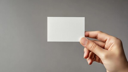 Obraz premium Mockup square empty blank white postcard holds the man in his hand Isolated on a gray background : Generative AI