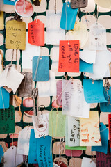 Background of colorful handwritten hanging tags on lattice work