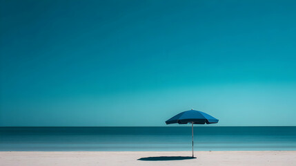 Fototapeta premium A tranquil blue beach umbrella stands against a clear sky, embodying a minimalist coastal vibe.