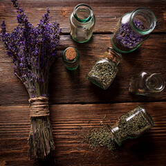 Photo of Dried Herbs on Antique Oak Table with Glass Bottles Square Format