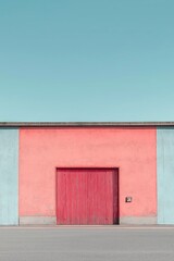 A pink and blue building facade with a red corrugated door, depicting a modern and colorful architectural style.
