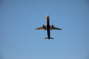 Beautiful airplane takes off at sunset. Sunny evening. Large passenger plane.