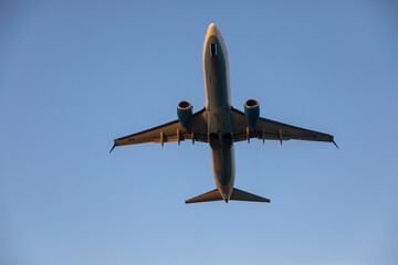 Beautiful airplane takes off at sunset. Sunny evening. Large passenger plane.
