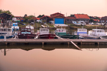 Pinasse, a typical boat from the Arcachon basin in France, in a port with oyster huts © sissoupitch