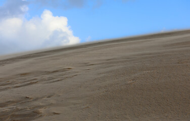 dune moved by the wind in the desert and the white clouds on the horizon without anyone