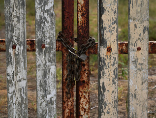 Old wooden fence with a lock in front