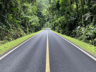 Fototapeta premium Narrow rural road with worn asphalt and dense greenery on both sides, rural infrastructure, nature and road