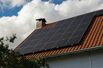 Black solar panels on a red tile roof