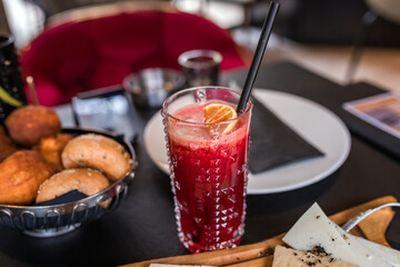 Refreshing red drink with food in the background at a old fashioned party