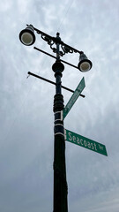 Obraz premium Seacoast Terrace and Riegelmann Boardwalk crossroads street sign on a street lamp in Brighton beach in Brooklyn