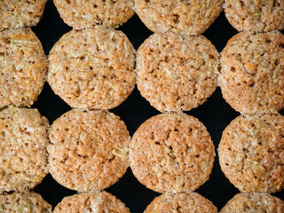 Top view of homemade vegetables muffins in baking tray. Close up view of cupkaces with zucchini, carrots, apple and cinnamon on black background. Sweet vegetables homemade muffins