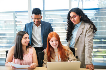 Group of Young Cheerful Business People Collaborating on a New Project While Sitting in Well-lit Conference Room