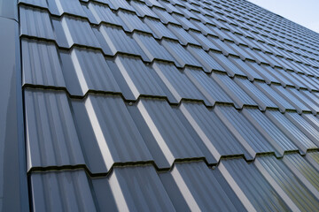 Discover modern metal roof tiles with a stylish wave pattern, ideal for contemporary architecture and design © Aleksey