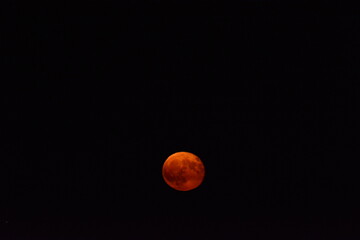 glowing red moon shining against a dark night sky
