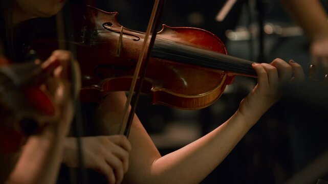 Footage of the violin section in a classical jazz orchestra &mdash; Female violinist.
