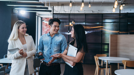 businesspeople discussing papers and working on laptops, indicating active discussion or presentation,with a laptop in the background.