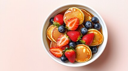 Wholesome Breakfast Delight Close-Up of Mini Pancakes, Berries, and Syrup in White Bowl on Pink Surface - Fresh, Juicy, and Delicious