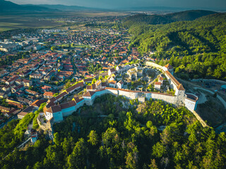 Aerial view of a panoramic landscape surrounded by mountains on the horizon, featuring lush green meadows.