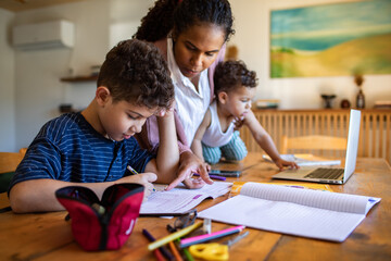 Mother helping children with homework at home