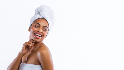 Cheerful black girl wrapped in towels just after shower looking at free space, panorama